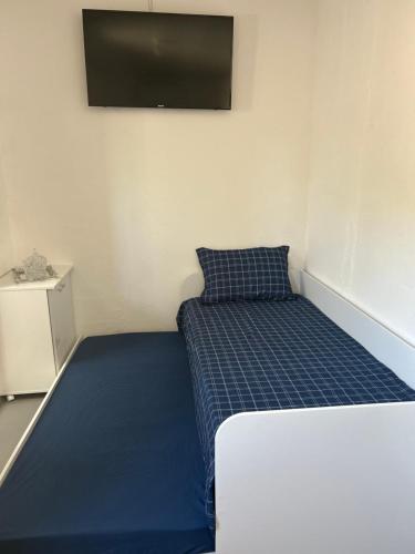 a small bedroom with a bed and a flat screen tv at Espaço para Hermanos in São Gabriel