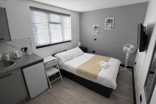 a small bedroom with a bed and a sink at 12 London Deluxe Studios in Streatham Vale