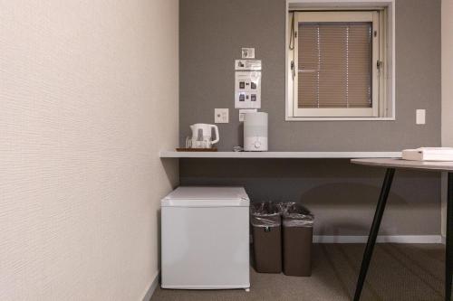 a small kitchen with a counter and a table at Tourist Hotel New Aoki 観光ホテル ニュー青木 in Tokyo