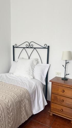 a bedroom with a bed and a dresser with a lamp at La Viñita in El Paso