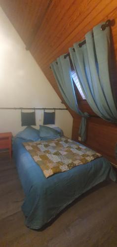 a bedroom with a bed and a window with blue sheets at Gite des 3 Cailloux in Leulinghen-Bernes