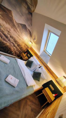 a bedroom with a bed with pillows and a window at Łykolańczyk-Chatki z JACUZZI in Polańczyk