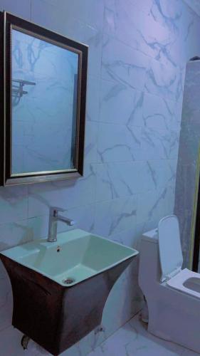 a bathroom with a sink and a toilet and a mirror at Apparemment 2 chambres- Lemba Salongo in Kinshasa
