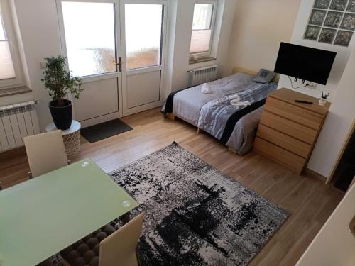 a bedroom with a bed and a desk and a table at Apartmán Eliška v Karolince in Karolinka
