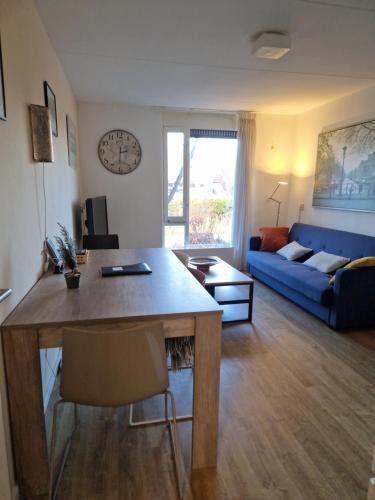 a living room with a table and a blue couch at Johan's B&B - Since 2014 roofterrace and cheap parking in Amsterdam
