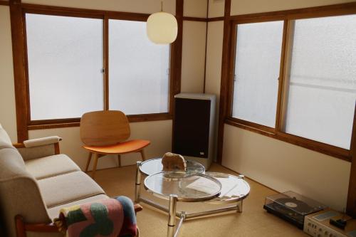 a living room with a couch and a glass table at Shoe Cream Inn Higashikawa in Higashikawa