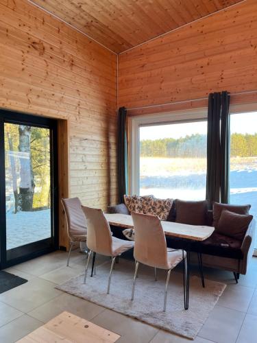 una sala da pranzo con divano, tavolo e sedie di W lesie nad rzeką a Rolbik