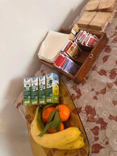 un vassoio con banane, arance e altra frutta su un tavolo di Lemon house a Montebelluna