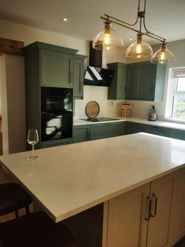 a kitchen with green cabinets and a white counter top at The Lake House, cong in Cong