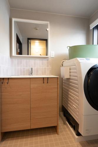 a bathroom with a sink and a mirror at AURA YUZAWA Apartment Hotel - Spacious 1Bedroom Apartment with Large Living Room Sleeps 4 to 6, Bedroom with 2-Double Beds, Living Room with 1-Double Bed & 1-Sofa Bed in Yuzawa