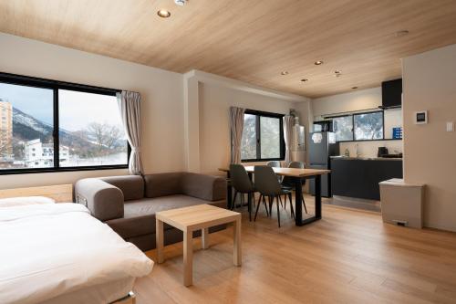 En eller flere senge i et værelse på AURA YUZAWA Apartment Hotel - Spacious 1Bedroom Apartment with Large Living Room Sleeps 4 to 6, Bedroom with 2-Double Beds, Living Room with 1-Double Bed & 1-Sofa Bed