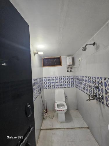 a bathroom with a white toilet in a room at AnjuShyam HomeStay in Agra