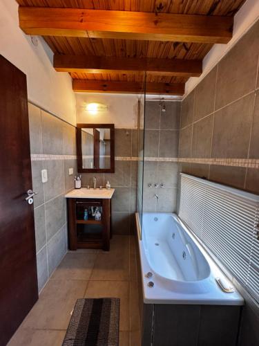 a large bathroom with a tub and a sink at La Morondanga in Villa Yacanto