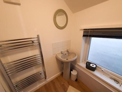 a bathroom with a sink and a window at FLAT 2 Seven Cambrian Square First Floor Flat in Newtown