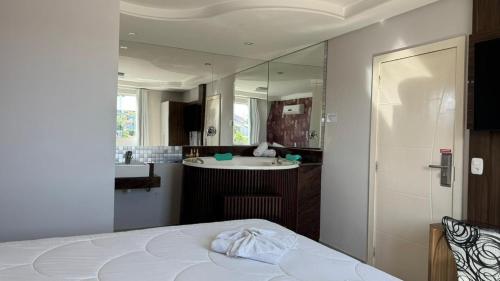 a bathroom with a bed and a sink and a mirror at Hotel Paraiso in Correia Pinto