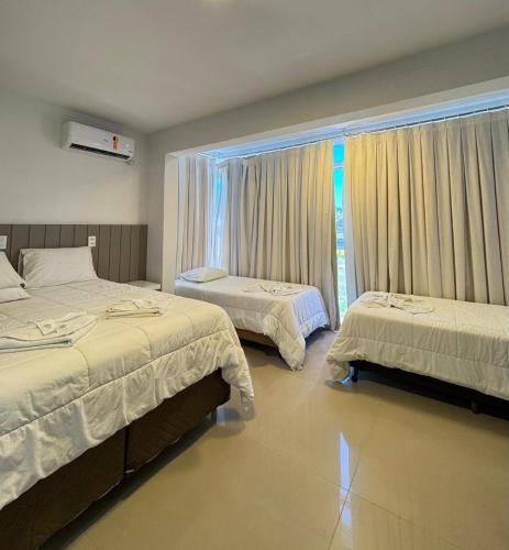 a bedroom with two beds and a window at Hotel Paraiso in Correia Pinto