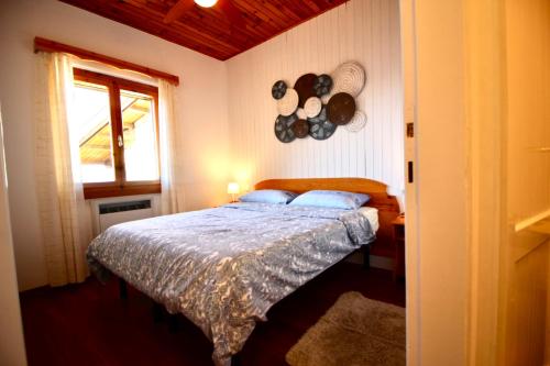 a bedroom with a bed with blue pillows and a window at VISTA BELLA am Gardasee in San Zeno di Montagna