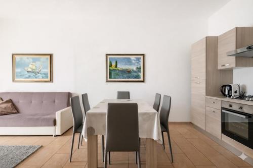 a kitchen and dining room with a table and a couch at Dimoras 3BR City Center Terrace & Parking in Olbia
