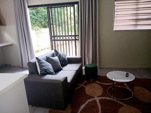 a living room with a couch and a window at The Corner Nest in Roodepoort