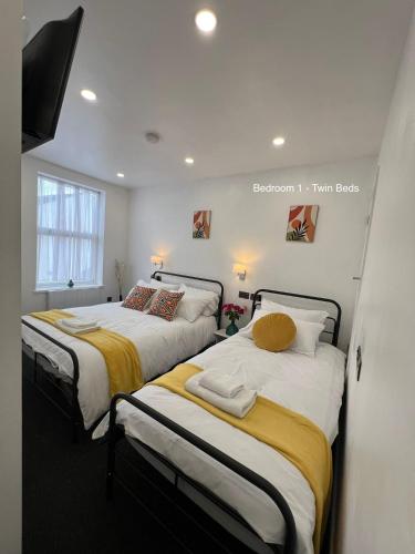 een slaapkamer met 2 bedden met gele en witte lakens bij Florence House - 3 Twin Rooms with Two Beds Per Room Weekly Stays Ok Contractor Accommodation Best-in-Class in West Bromwich