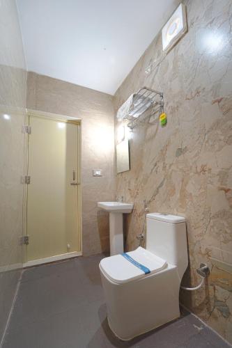 a bathroom with a toilet and a sink at Estoria Hotel and Resort in Mysore