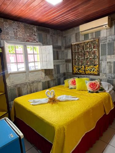 a bedroom with a yellow bed with a bow on it at Pousada Alto Astral in Olinda