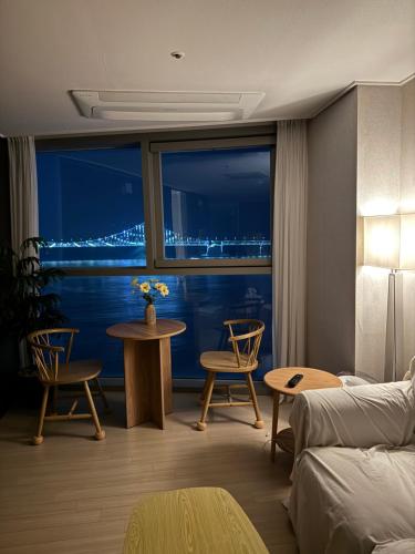 een woonkamer met een bank en een tafel met stoelen bij Gwangan cozy in Kwangan-dong