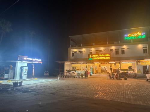 un edificio con stazione di servizio di notte di Kumaran Residency a Dindigul