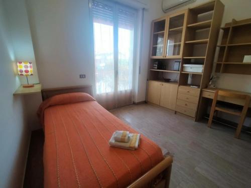 a bedroom with a bed and a desk and a window at CasaTreFontane in Bovalino Marina