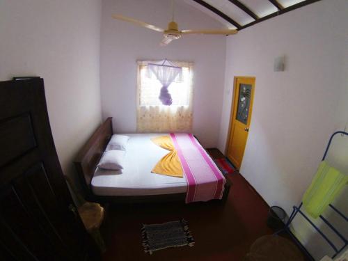 a bedroom with a bed in a room with a window at Dilan Guest in Mirissa