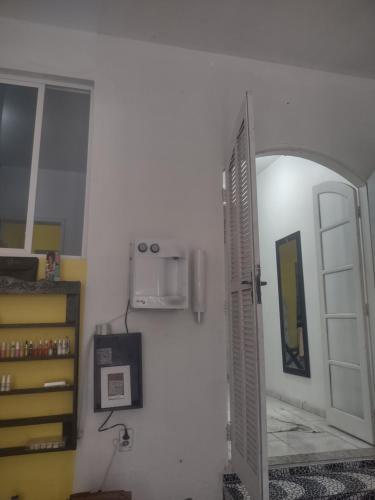 a room with an open door and a microwave at Espaço em Pero hospedagem in Cabo Frio