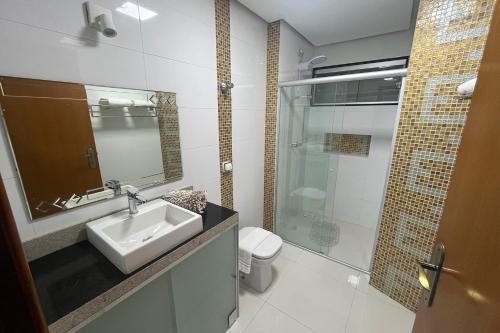 a bathroom with a sink and a shower and a toilet at Mega Palace Hotel in Morrinhos
