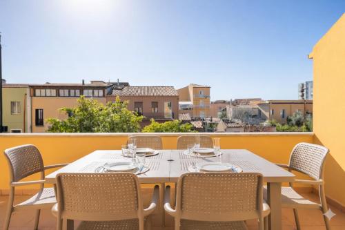 een tafel en stoelen op een balkon met uitzicht bij Dimoras Bellissimo Appartamento Centrocittà in Olbia