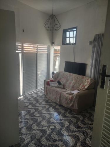 a living room with a bed and a window at Espaço em Pero hospedagem in Cabo Frio