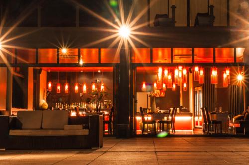 a restaurant with a bar at night with lights at The Houben - Adult Only in Ko Lanta