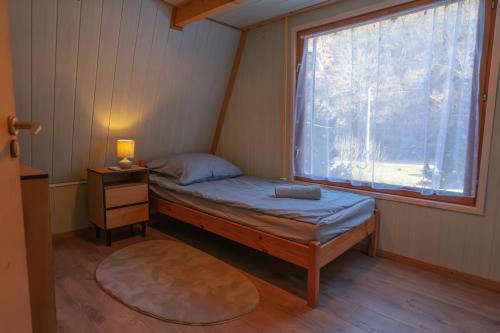 a small bedroom with a bed and a window at Élet Fája Vendégház in Kemence