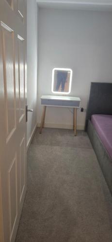 a room with a desk with a laptop on a table at SQdreamshome in Dunstable