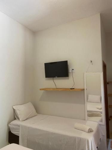 een kamer met twee bedden en een tv aan de muur bij Beach Chalet Preá in Prea
