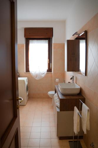 a bathroom with a sink and a toilet and a window at Urban Chic Apartment in Valmontone