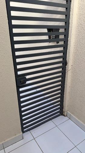 een metalen deur in een kamer met een tegelvloer bij FlatsRose CH Flamboyant Conforto e qualidade in Goiânia