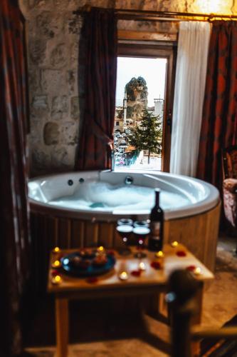 a bath tub in a room with a window at Young Cave Hotel in Ortahisar
