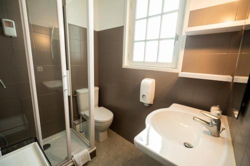 un bagno con lavandino, WC e finestra di Gite de la Baie - Morgat a Crozon