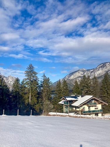 a house in the mountains with snow on the ground at Haus Waldfrieden in Bischofswiesen