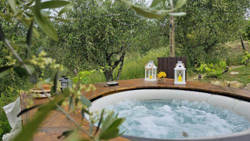 una vasca idromassaggio in un giardino con due candele di Panoramic Villa In The Lucca Hills a Capannori
