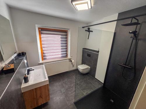 a bathroom with a sink and a toilet and a window at Ferienwohnung Gleesbergquelle in Aue-Bad Schlema
