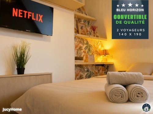 una stanza d'albergo con un letto e una TV a parete di Bleu Horizon a Berck-sur-Mer