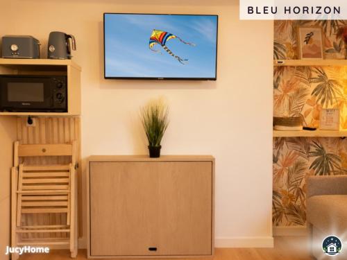un soggiorno con una tv e un aquilone sul muro di Bleu Horizon a Berck-sur-Mer