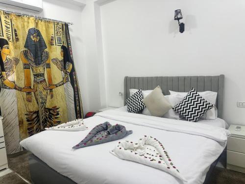 a bedroom with a bed with two shoes on it at Hamed's House Luxor in Luxor