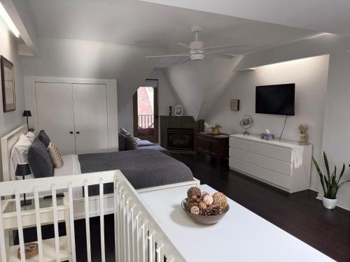 a bedroom with a bed and a tv on a wall at Bright, Private, Peaceful Suite with Retail Conveniences Steps Away in Toronto