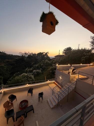 a balcony of a house with chairs and a sunset at Wildcrest Homestay in Madikeri